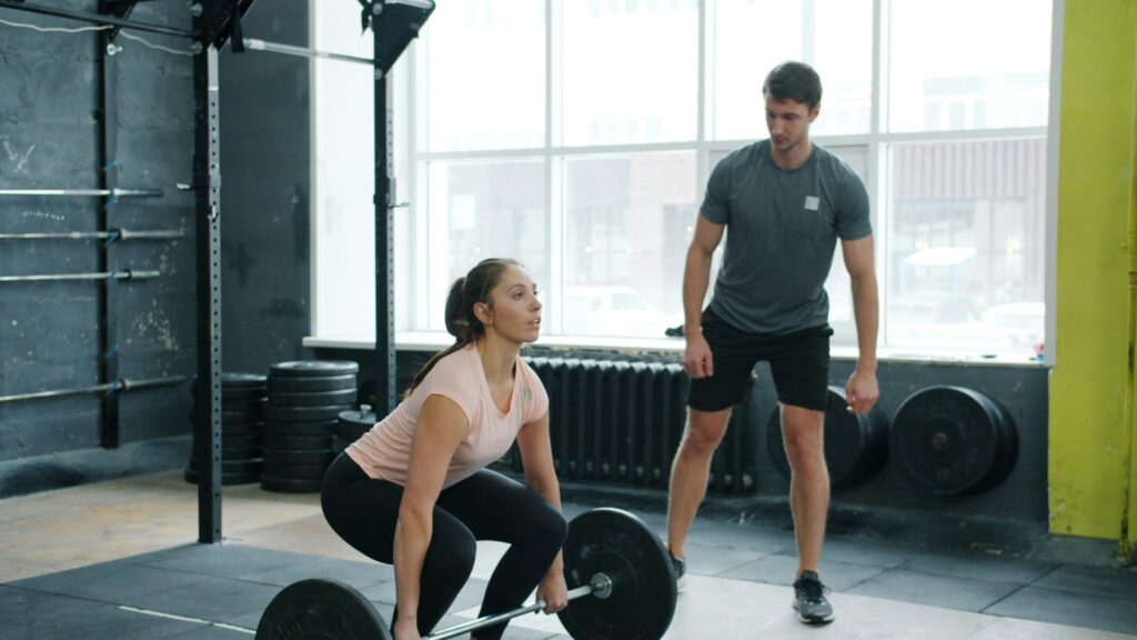 パーソナルトレーナーがクライアントを指導しながら励ましている様子