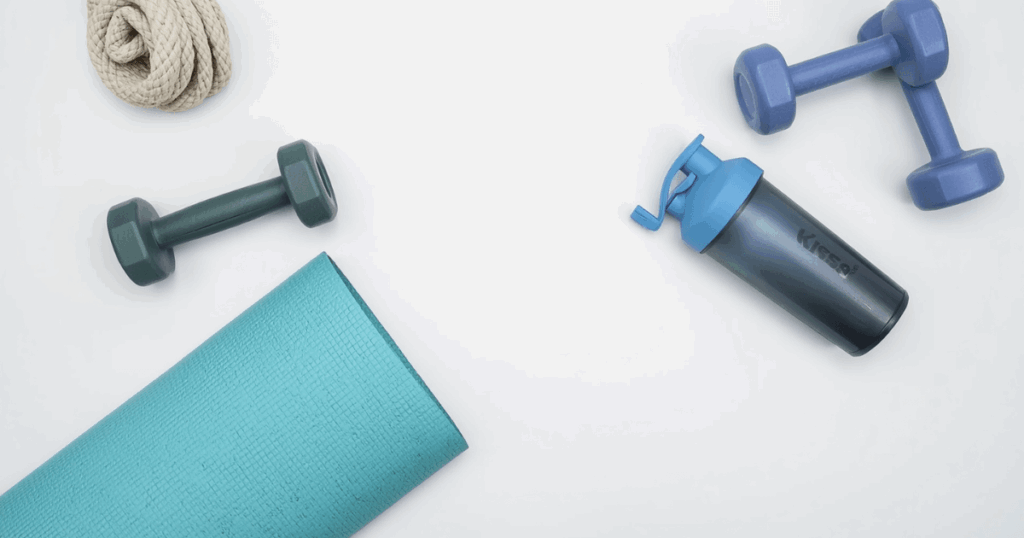 ヨガマット・ダンベル・プロテインシェイカーが並んだトレーニング用品