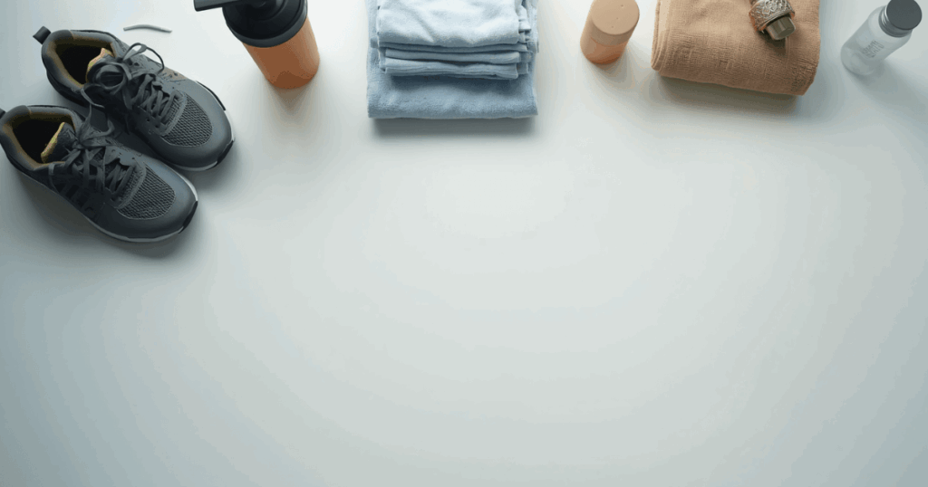 筋トレの継続習慣を象徴するトレーニングシューズとウォーターボトルが並ぶ明るいジムのイメージ