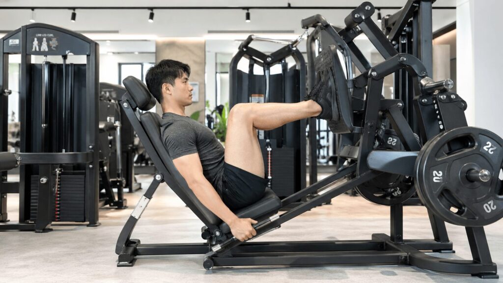 レッグプレスマシンで下半身を鍛えている男性の横から見たフォームショット
