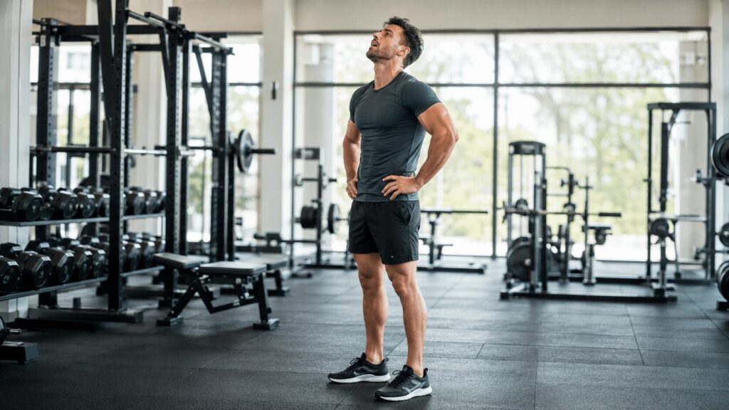 セット後に呼吸を整えながら追い込み度を確認するトレーニーのイメージ