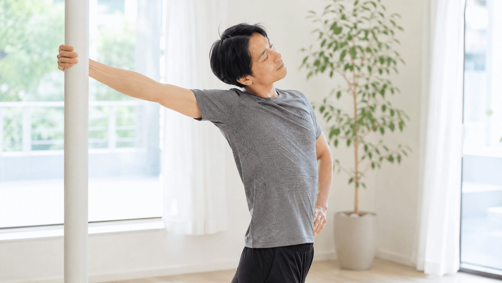 背中トレーニング後に広背筋を伸ばすストレッチをする男性のイメージ