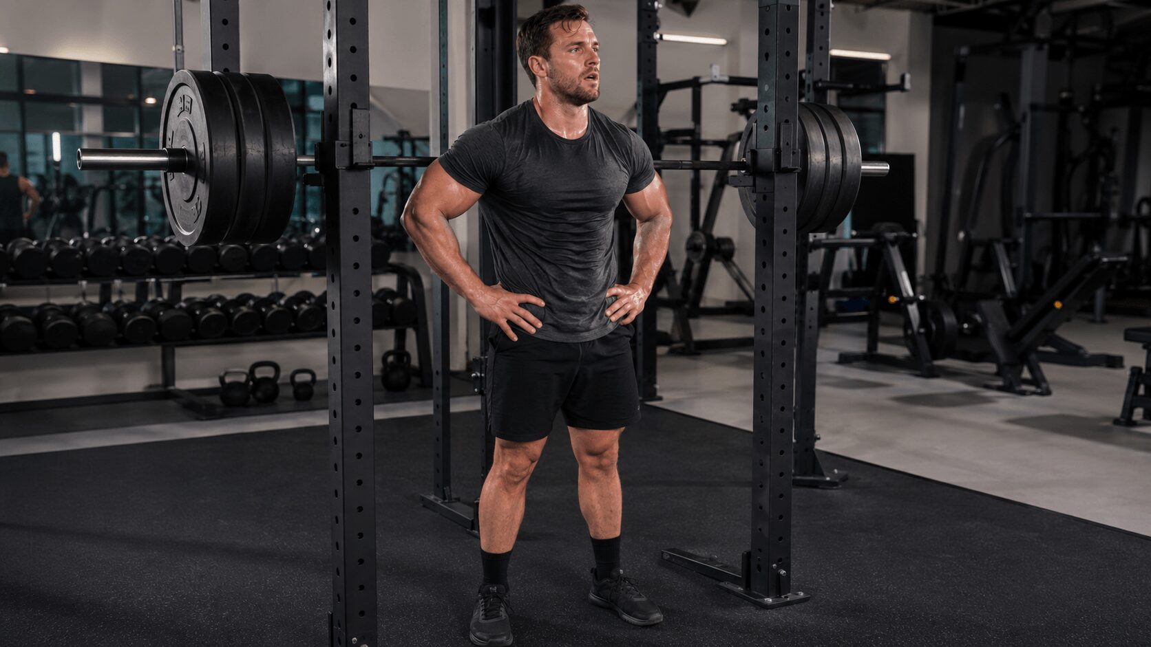 ジムでバーベルを使って力強く追い込んでいる30代男性の写真。筋肥大の刺激を与えるトレーニングのイメージ