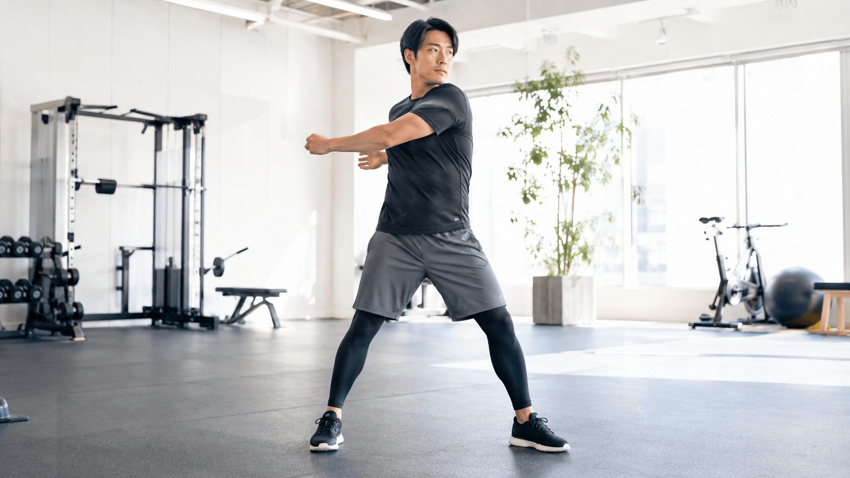 ジムで動的ストレッチを行う30代男性のイメージ