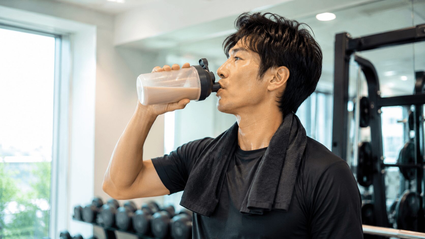 トレーニング後にプロテインを飲んで疲労回復をはかる男性