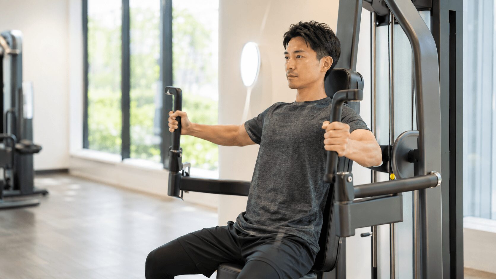 空いている時間帯のジムでマシンを使い落ち着いてトレーニングする初心者男性