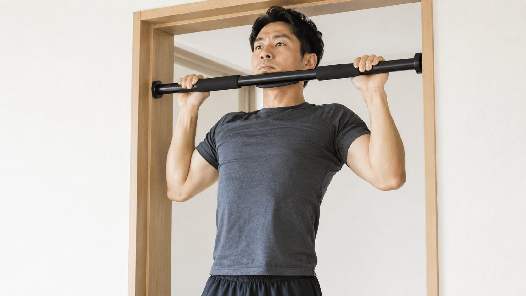 懸垂のトップ位置であごがバーの高さまで上がった状態の男性
