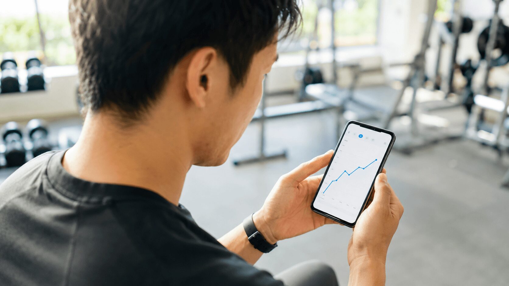 スマホでトレーニング記録を確認する様子 筋トレのメンタル効果を記録で可視化