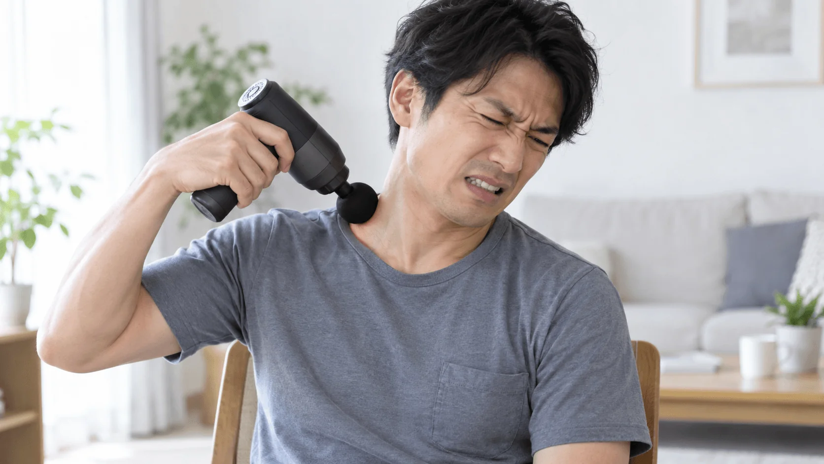 マッサージガンを肩に当てているが強く押し付けすぎている悪い使用例