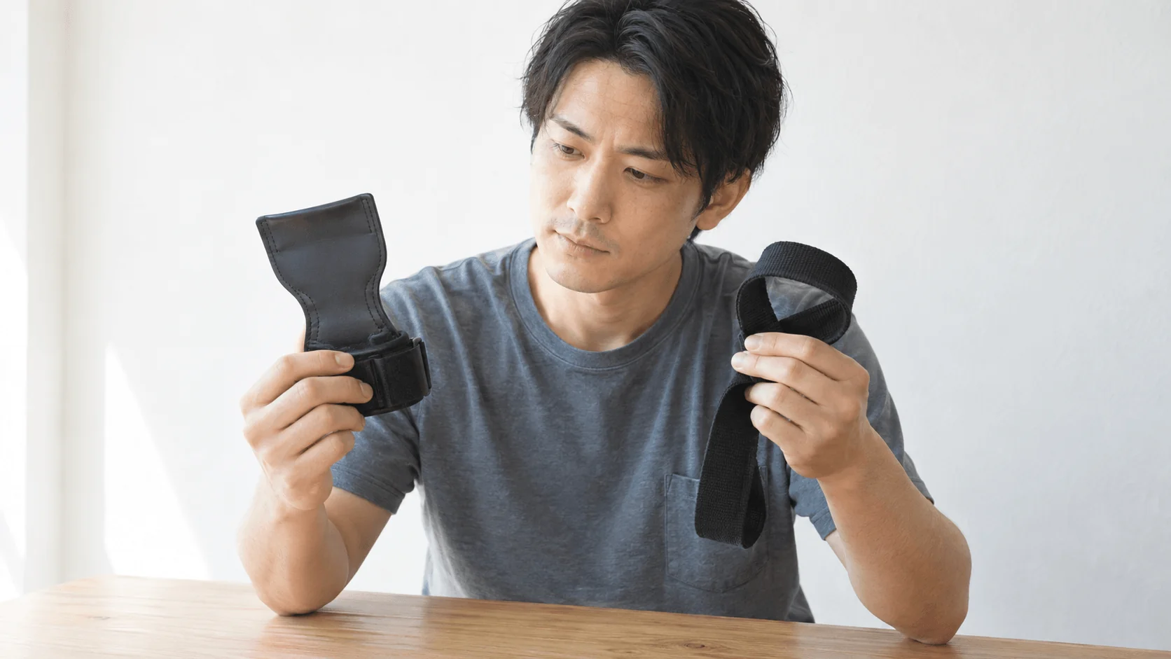 リストストラップとパワーグリップのどちらを買うか選んでいる男性