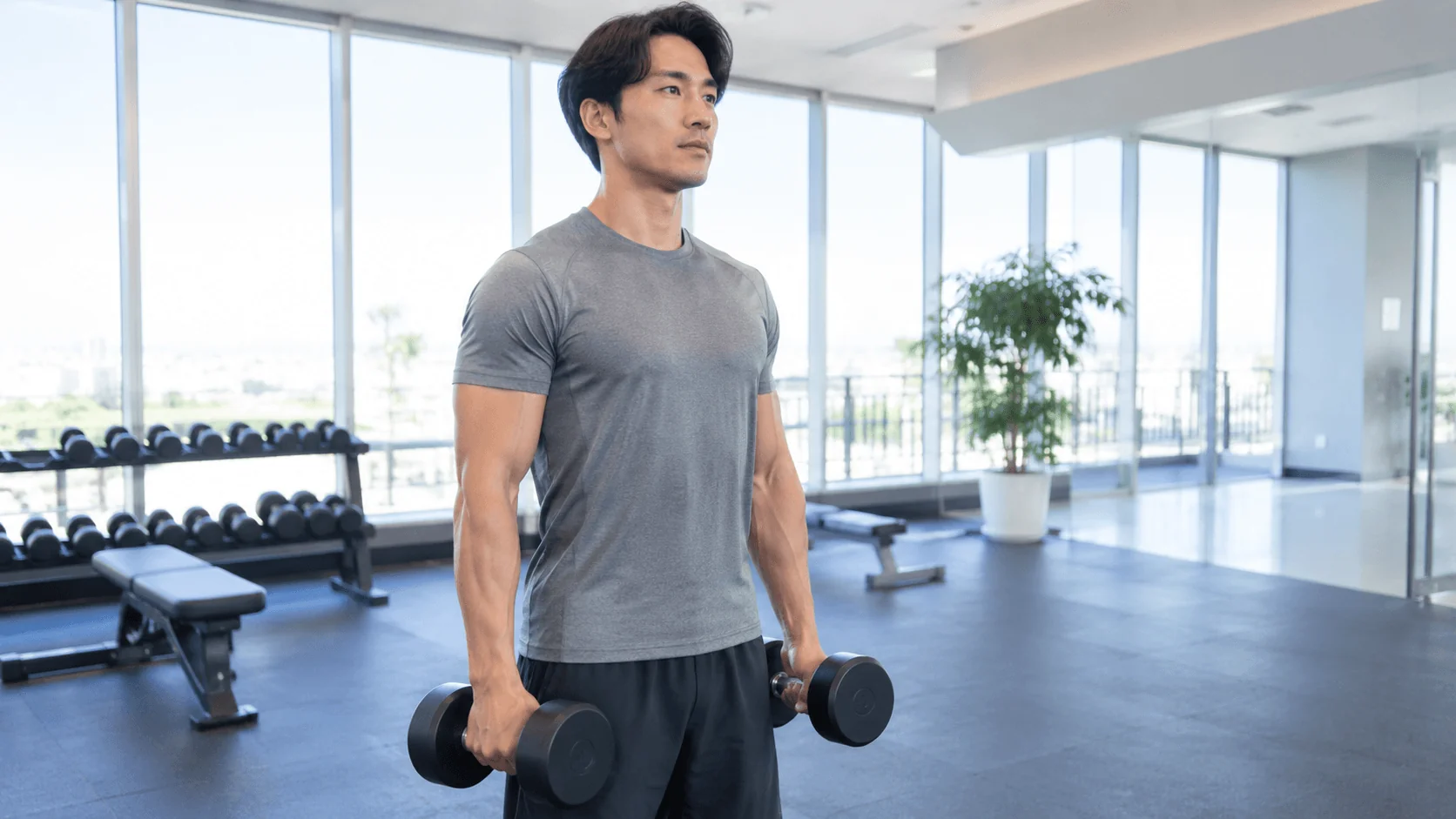 握力補助ギアを使わず素手でダンベルを握りトレーニングする男性